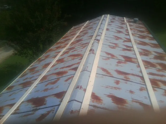 Rusted metal roof panels with new wood purlins before replacement — Storm Damage Roof Repair in Magalia by Roofing Brothers