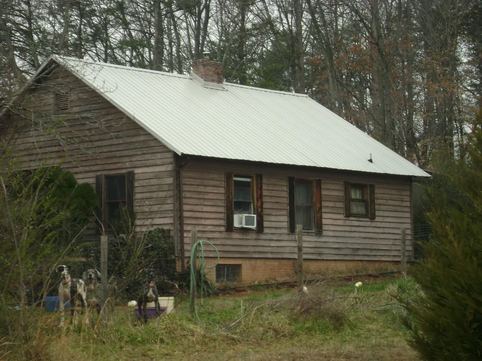 White metal roof on an old wood sided farmhouse, from a Metal Roof Installation job in Magalia